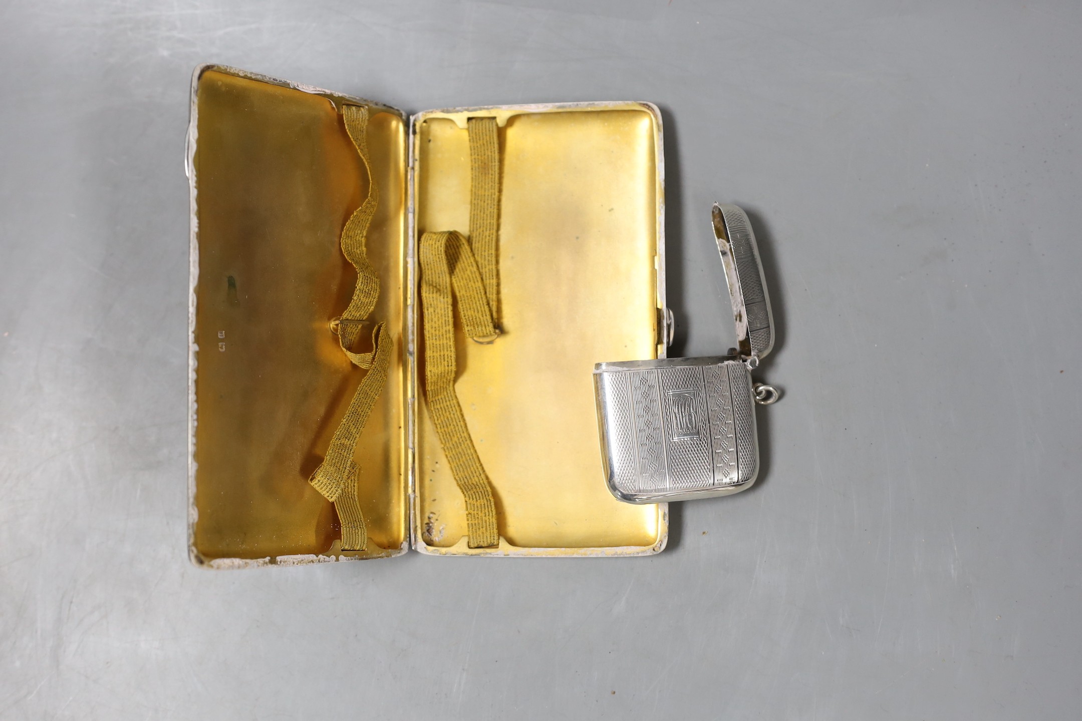 A George V engine turned silver cigarette case, 15cm, and a silver vesta case, gross 8oz.